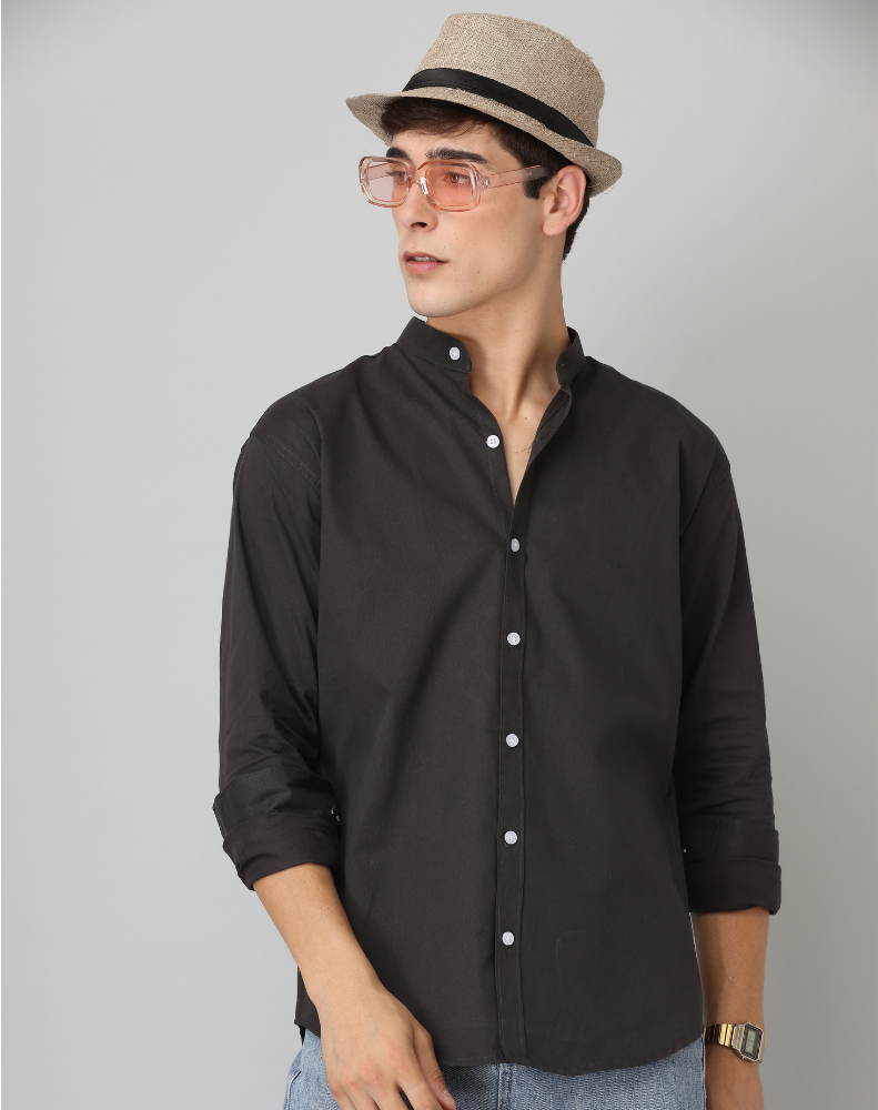 Man wearing a black shirt, beige hat, and glasses on a gray background