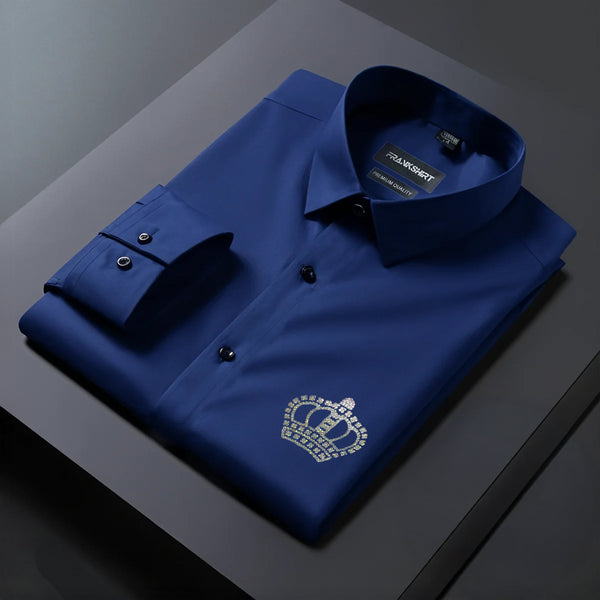 Folded blue shirt with a crown emblem on a dark surface