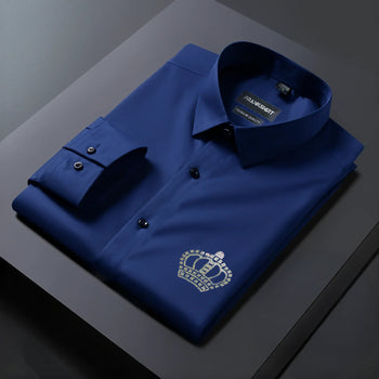 Folded blue shirt with a crown emblem on a dark surface