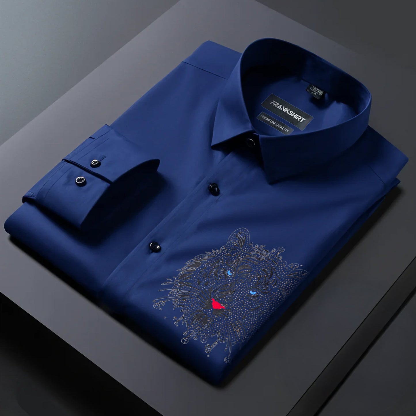 Folded blue shirt with a tiger emblem on a dark surface