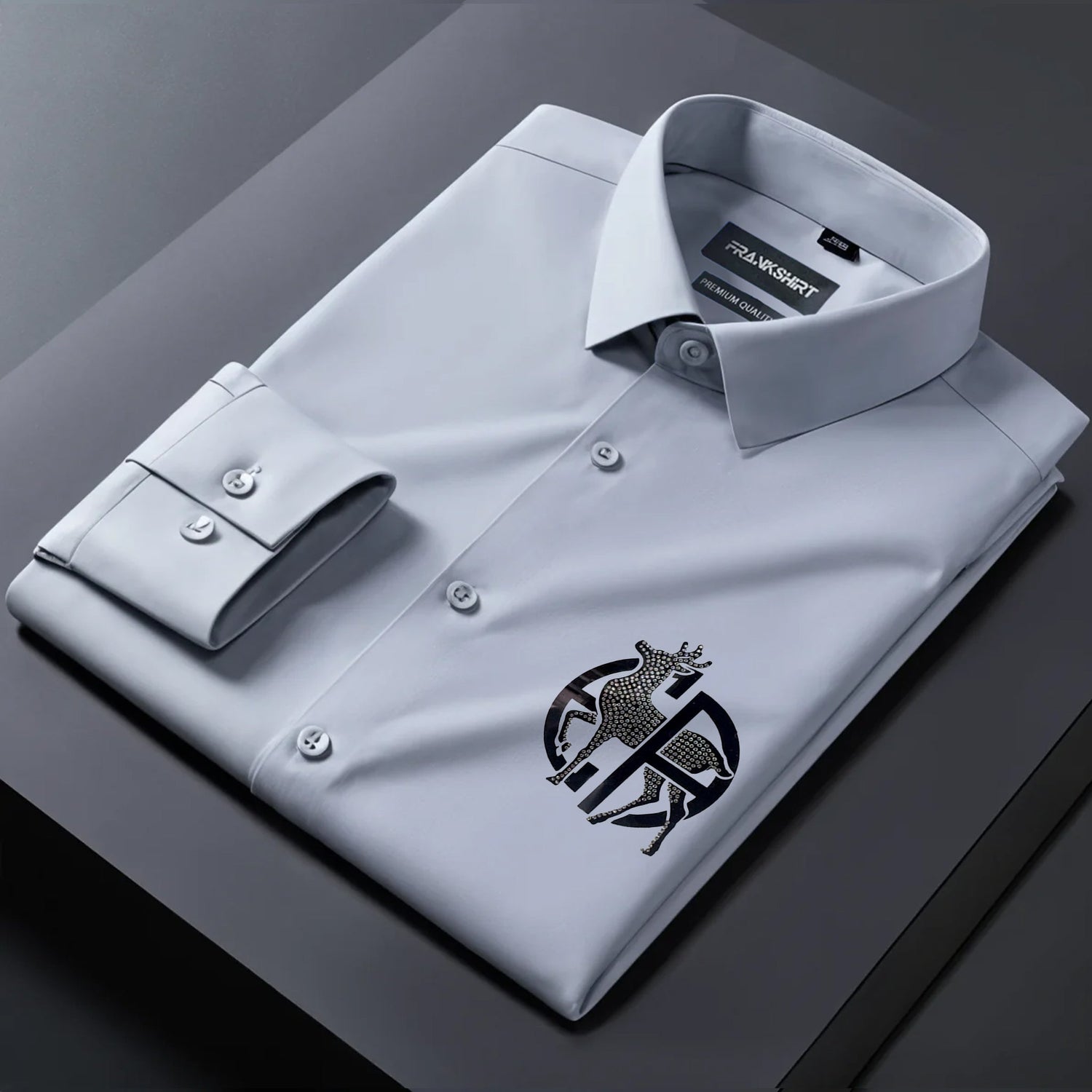 Gray dress shirt with a logo on a dark surface