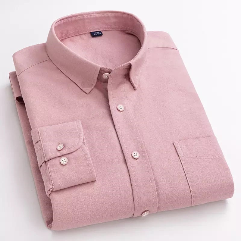 Folded pink cotton shirt on a plain background, displaying the front view with buttons and a collar.