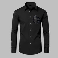 Black dress shirt with a logo on the chest against a gray background