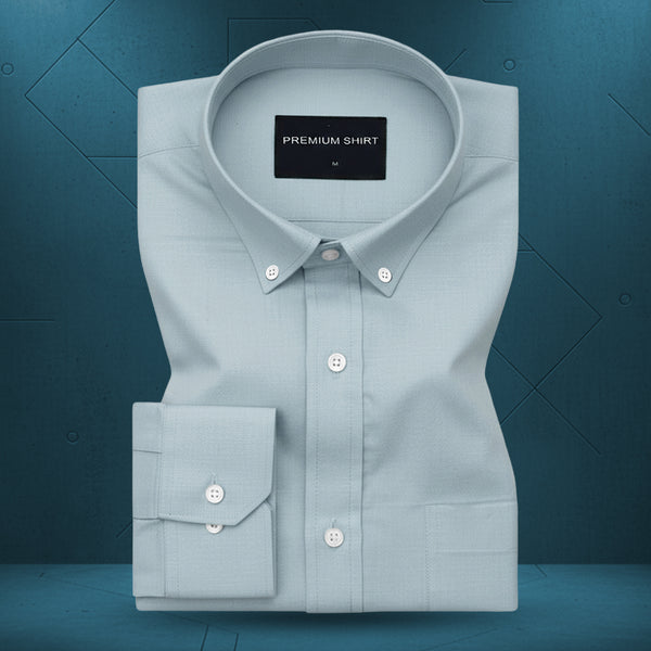 Folded light blue shirt with a visible brand label on a dark blue background