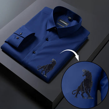 Blue shirt with embroidered lion design on a dark surface