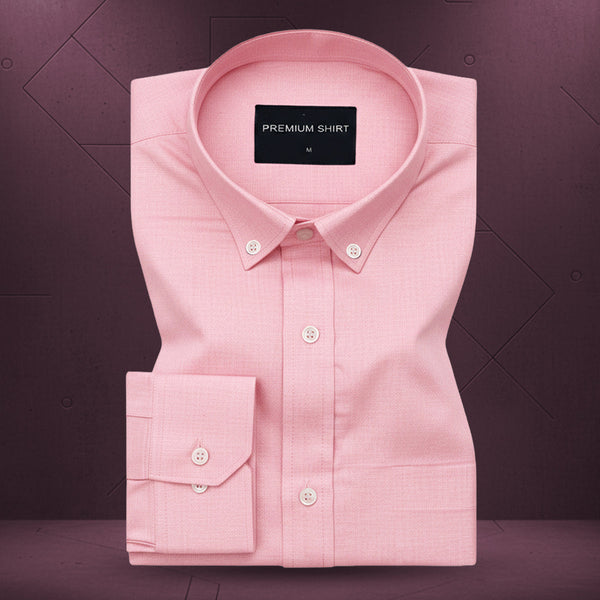 Folded pink shirt with a label on a purple background