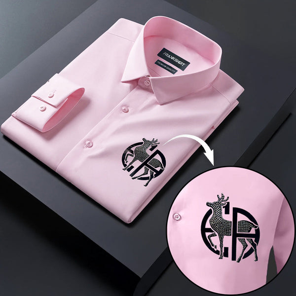 Pink dress shirt with a brand logo on a dark surface, showing a close-up of the logo.