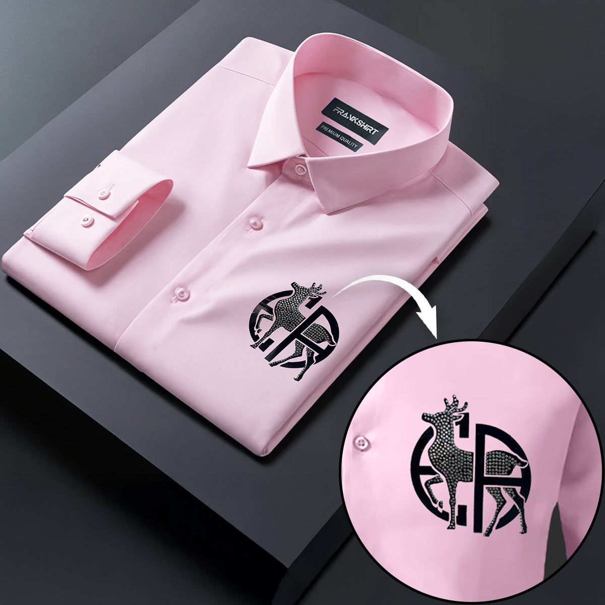 Pink dress shirt with a brand logo on a dark surface, showing a close-up of the logo.