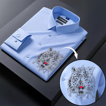 Folded light blue shirt with tiger embroidery on a dark surface