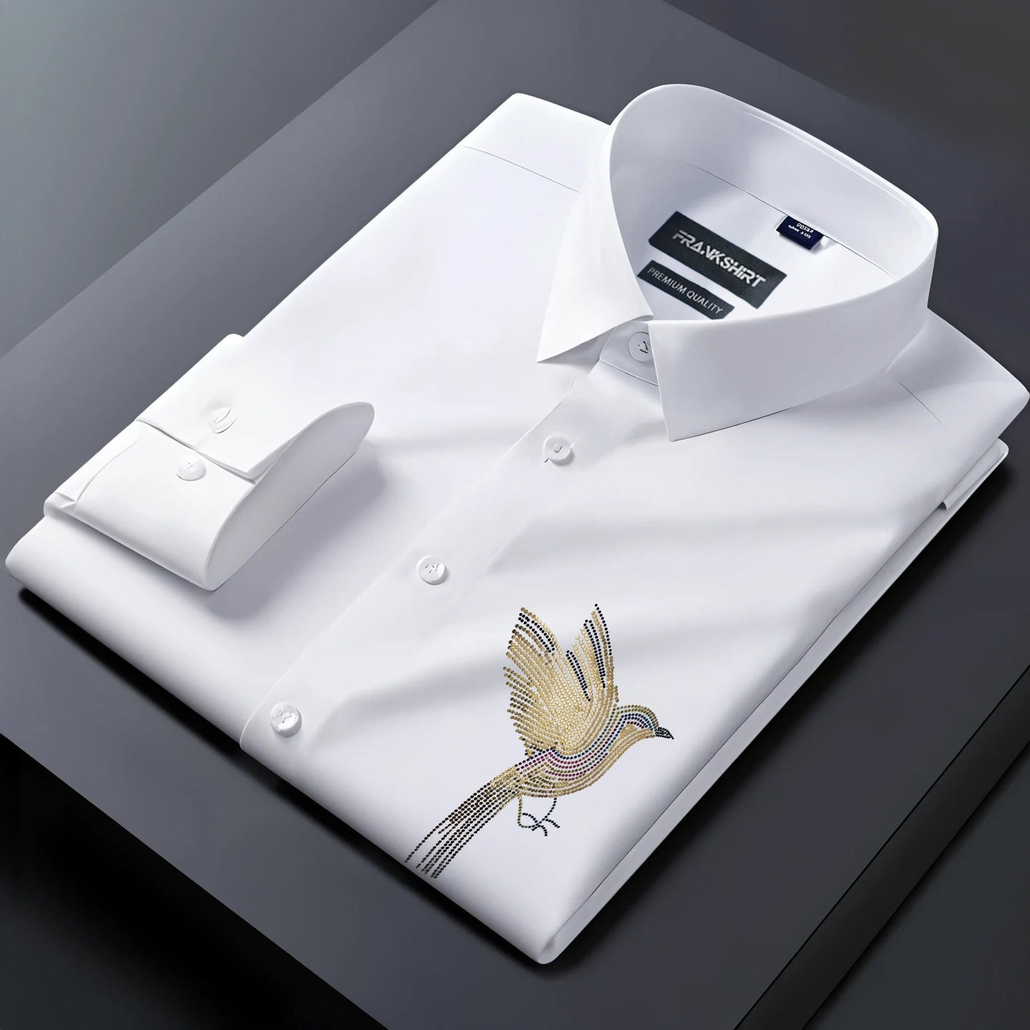 Folded white dress shirt with bird embroidery on a dark surface